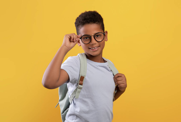 Szczęśliwy Afrykański amerykański chłopiec w okularach i plecaku - Zdjęcie, obraz