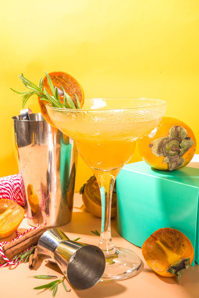 Alkoholowy napój alkoholowy, jesienny koktajl z margarity persymony, ze świeżymi owocami persymony i rozmarynem - Zdjęcie, obraz