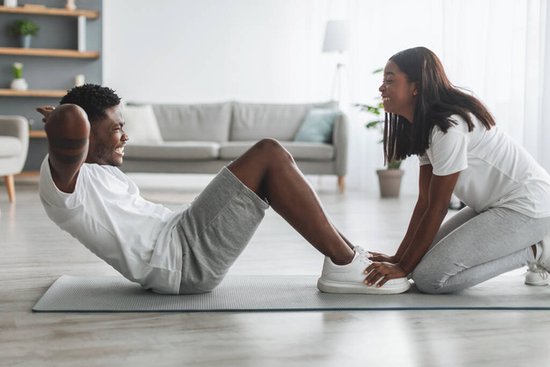 Young black couple doing crunches exercise on abs - Photo, Image