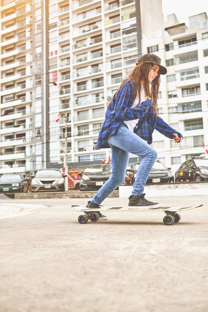Girl having fun riding skateboards at skate park, Portrait of smiling young female skateboarder holding her skateboard. Recreational Activity Concept. - 写真・画像