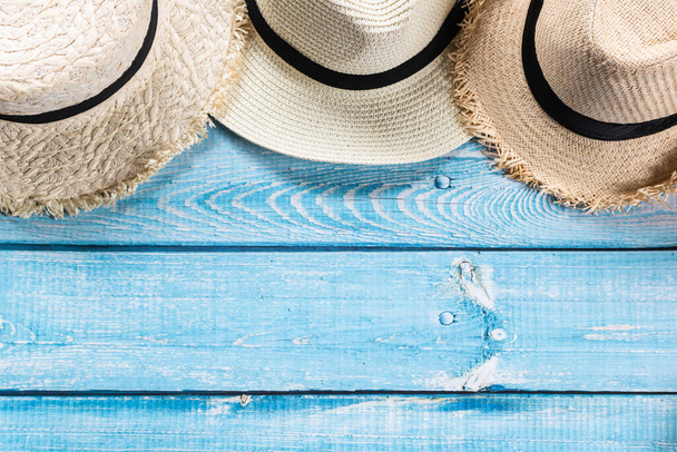 Sombreros de paja sobre fondo de madera azul claro, playa y concepto de verano. - Foto, imagen