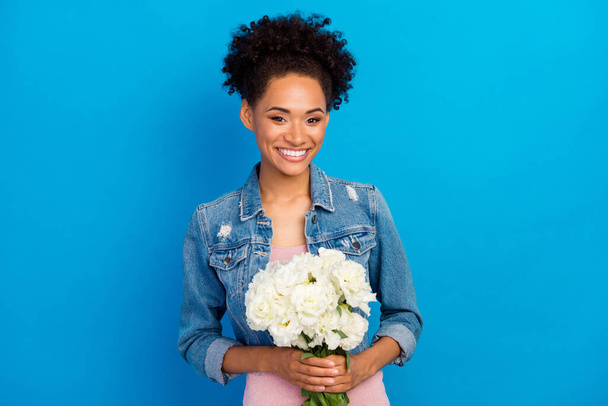 Photo of young happy positive woman hold flowers good mood smile isolated on blue color background - Фото, изображение