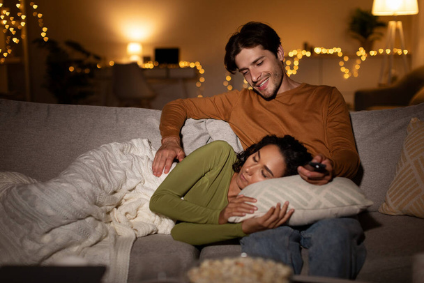 ボーイフレンドは夜にテレビ室を見て寝ているガールフレンドを見て - 写真・画像