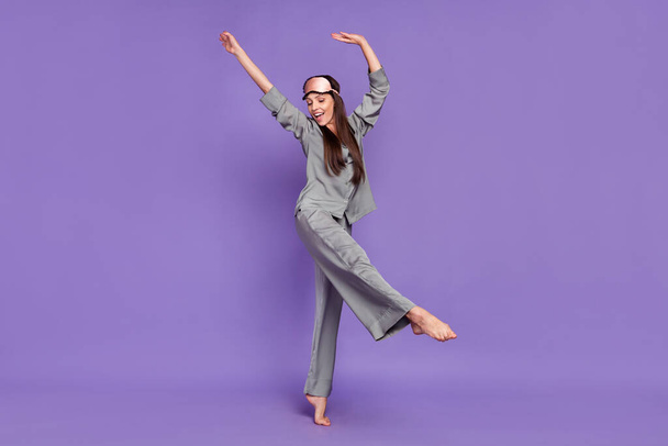 Full size photo of cheerful young positive woman wear nightwear dance enjoy weekend isolated on purple color background - Foto, afbeelding