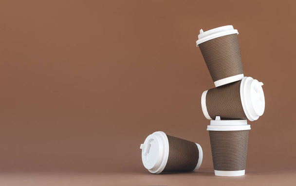 Montón de tazas de café desechables de papel marrón con tapas - Foto, imagen