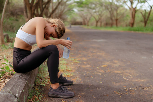 Woman tired after running in the forest - Фото, изображение