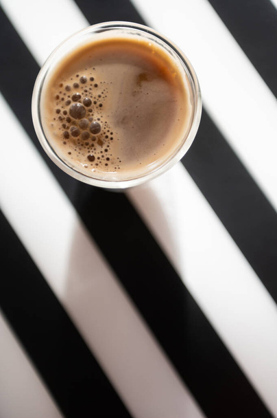 Close Up photo of cup with black coffee and shadow on black and white background - Fotografie, Obrázek