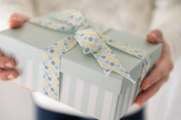 Close up photo of beautiful gift box in boy's hands at new year holidays or birthday celebration - Foto, afbeelding