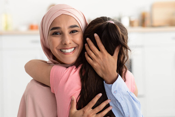 Matka i córka. Muzułmanka w hidżabie Obejmuje swoje małe dziecko - Zdjęcie, obraz