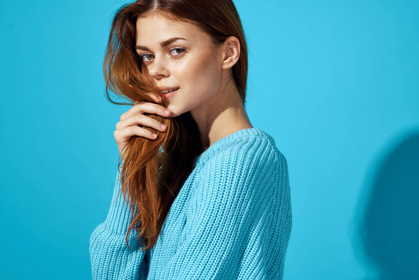 portret van een vrouw in een blauwe trui blauwe achtergrond Lifestyle - Foto, afbeelding