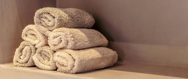 Salle de bains serviettes roll ups, design moderne spa salle de bien-être détails intérieurs. Serviettes propres empilées sur une étagère vue rapprochée, bannière, espace de copie, gabarit - Photo, image
