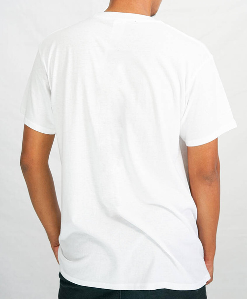 Camiseta maqueta en color blanco. un hombre con una camiseta para un catálogo de ropa de maqueta. gráfico de maqueta desde la vista posterior - Foto, imagen