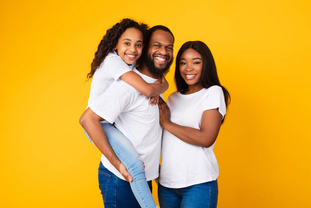 Hombre afroamericano posando con esposa e hija sonriente - Foto, imagen