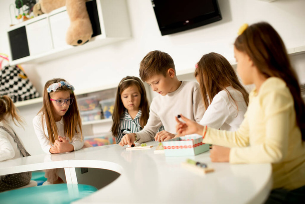 Gruppe kleiner Kinder spielt mit hölzernem Lernspielzeug für Vorschulkinder - Foto, Bild