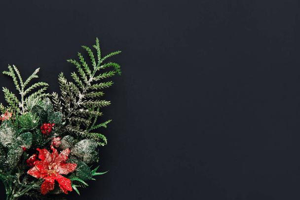 Sfondo natalizio. Ramo dell'albero di Natale su sfondo nero, vista dall'alto. Capodanno, posa piatta. Ricevuto. Focus selettivo. - Foto, immagini