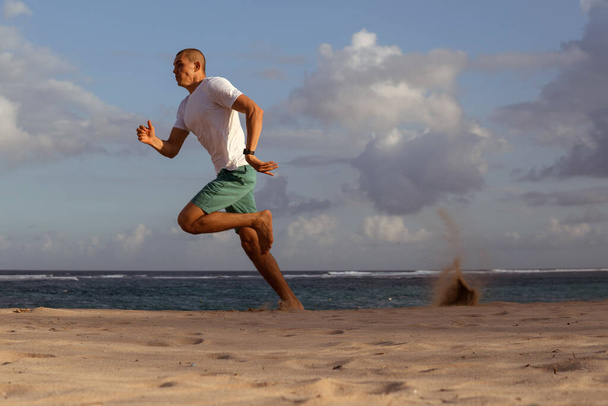 man doing sports on the beach - Фото, изображение