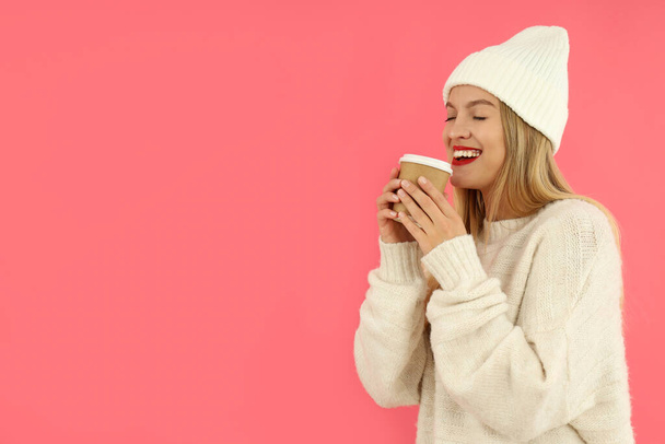 Attractive girl holds paper cup on pink background. - Φωτογραφία, εικόνα
