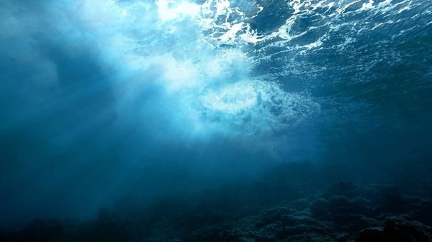 Artystyczne podwodne zdjęcie dzikich fal w promieniach światła.  - Zdjęcie, obraz
