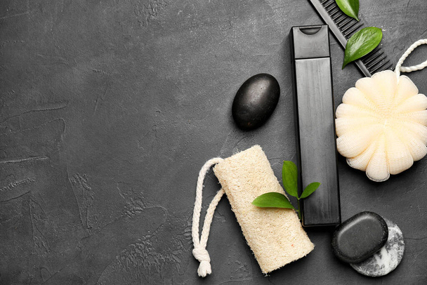 Composition with bottle of shower gel, sponges and spa stones on dark background - Photo, Image