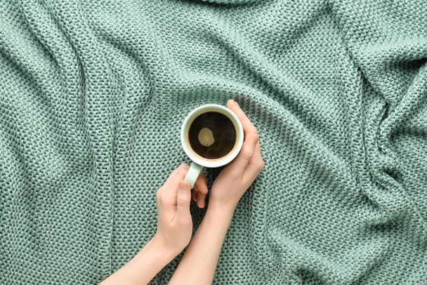 Donna in possesso di una tazza di caffè su sfondo tessuto colore - Foto, immagini