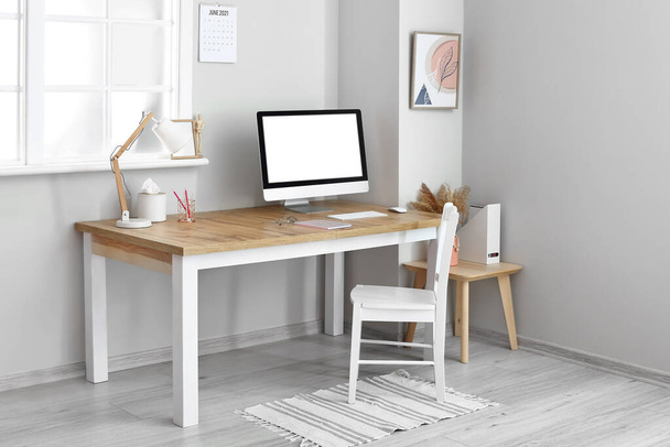 Modern workplace with blank computer screen in light office - Zdjęcie, obraz
