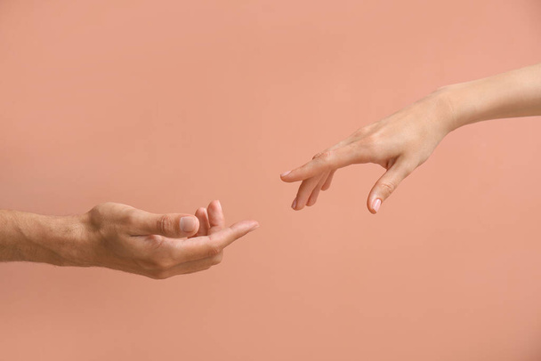 Woman and man reaching out to each other on beige background - Photo, image