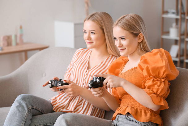 Junge Zwillingsschwestern spielen Videospiel zu Hause - Foto, Bild