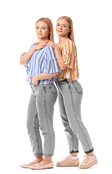 Krásné mladé dvojče sestry na bílém pozadí - Fotografie, Obrázek