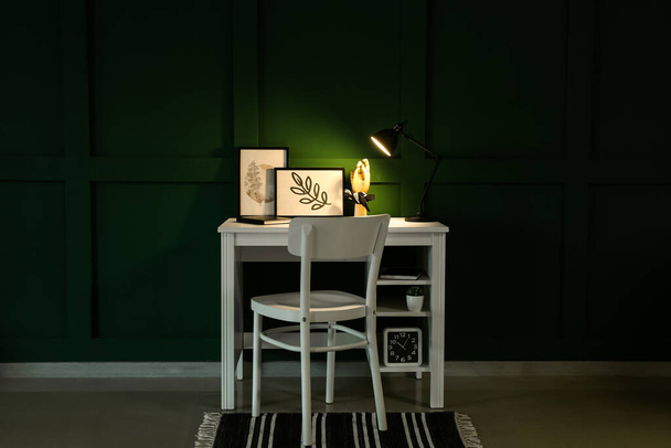 Τραπέζι με σκελετό, ξύλινο χέρι και λαμπάδα σε σκοτεινό δωμάτιο - Φωτογραφία, εικόνα
