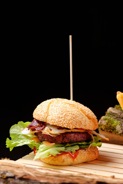 Gourmet fresh tasty American burger and french fries on wooden table - Foto, Bild