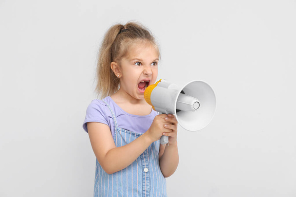 Protesting little girl with megaphone on light background - Foto, immagini