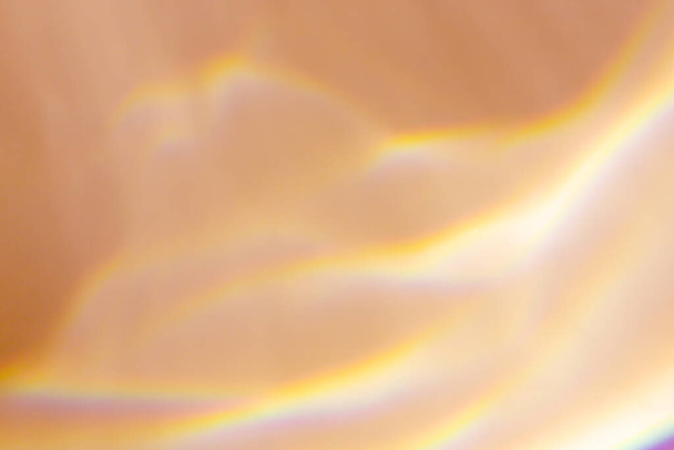 Krásný efekt lomu slunce na béžové pozadí. Kaustická textura. Mnohobarevné odrazy - Fotografie, Obrázek