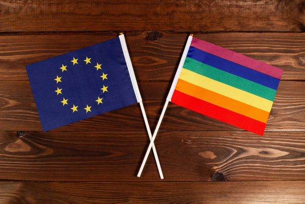 欧州連合の旗とLGBTの旗が交差した。この画像は国間の関係を示しています。インターネットやメディアでのテレビや記事のビデオニュースのための写真. - 写真・画像