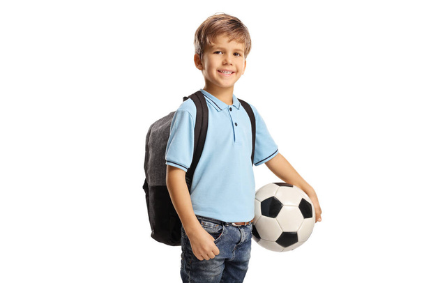 Cute schoolboy with a backpack holding a football isolated on white background - Φωτογραφία, εικόνα