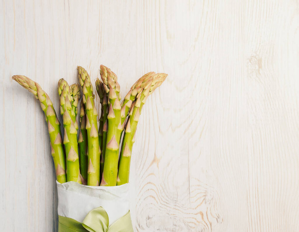 A bunch of fresh asparagus on a wooden gray table. - Fotografie, Obrázek