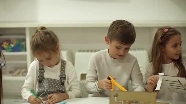 Ομάδα μικρών παιδιών που παίζουν με προνήπια ξύλινα εκπαιδευτικά παιχνίδια - Πλάνα, βίντεο