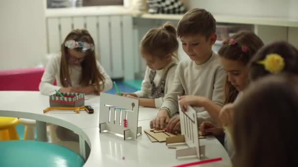 Ομάδα μικρών παιδιών που παίζουν με προνήπια ξύλινα εκπαιδευτικά παιχνίδια - Πλάνα, βίντεο