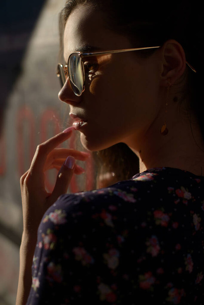 Портрет стильной молодой женщины. Брюнетка в сарафане позирует на улице. селективный фокус - Фото, изображение