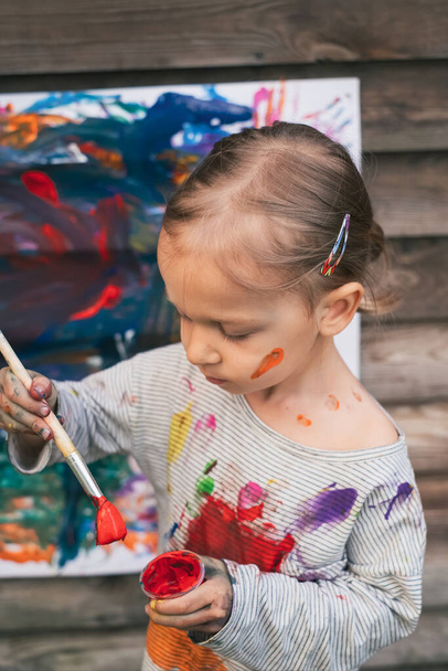 Nettes kleines Mädchen Malerei mit verschiedenen Farben - Foto, Bild