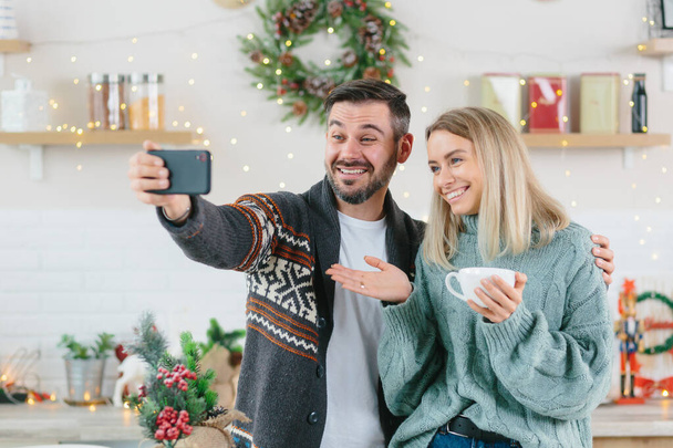 Couple in love husband and wife talk together on video call with friends and family, young family happily celebrates Christmas and New Year breath at home - Foto, Imagen