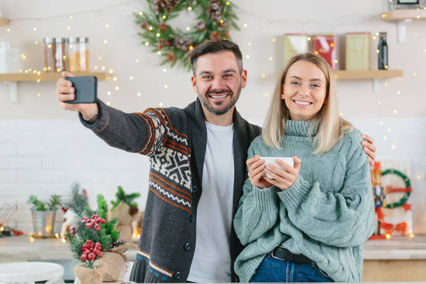 Couple in love husband and wife talk together on video call with friends and family, young family happily celebrates Christmas and New Year breath at home - Fotografie, Obrázek