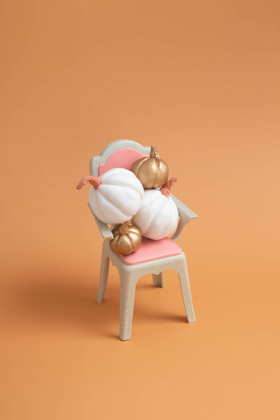 Syksyn luova asetelma valkoinen ja kulta kurpitsat tuolilla - Valokuva, kuva