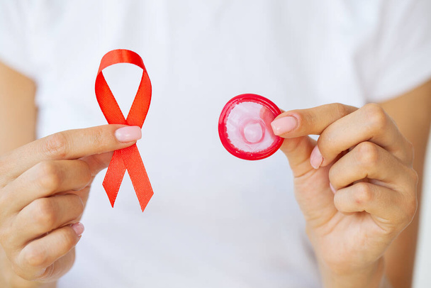 Ruban rouge main de femme VIH, ruban de sensibilisation à la Journée mondiale du sida. - Photo, image