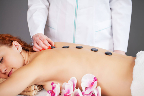 Gros plan sur jeune femme recevant un massage aux pierres chaudes
 - Photo, image
