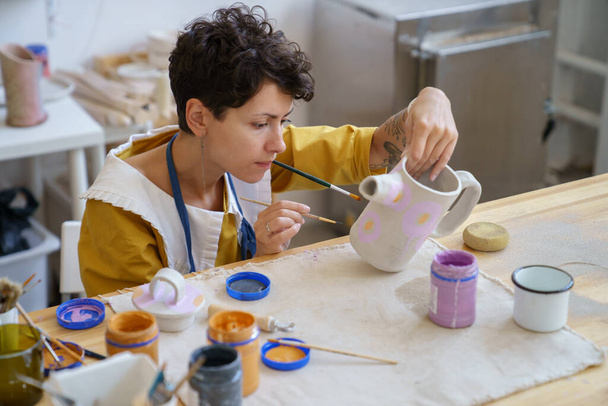 Young woman professional pottery artist work in studio. Teacher of ceramic art preparing clay potter - Photo, Image