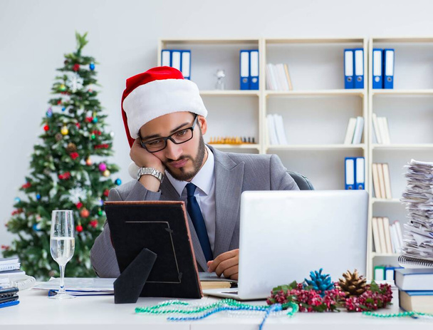 Jeune homme d'affaires célébrant Noël au bureau - Photo, image