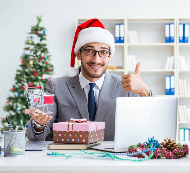 Jonge zakenman viert kerst op kantoor - Foto, afbeelding