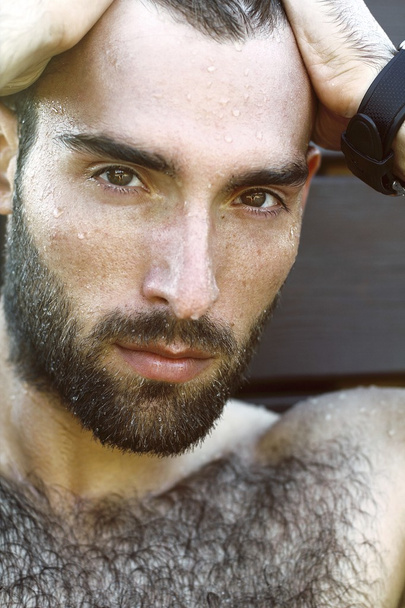 Fashion Portrait of handsome masculine guy with drop of water on face with Brown dark eyes Beard and mustache - Fotó, kép