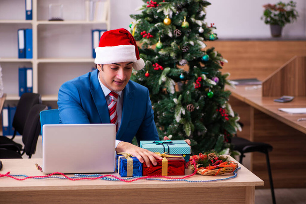 Young male employee celebrating Christmas at workplace - Photo, Image