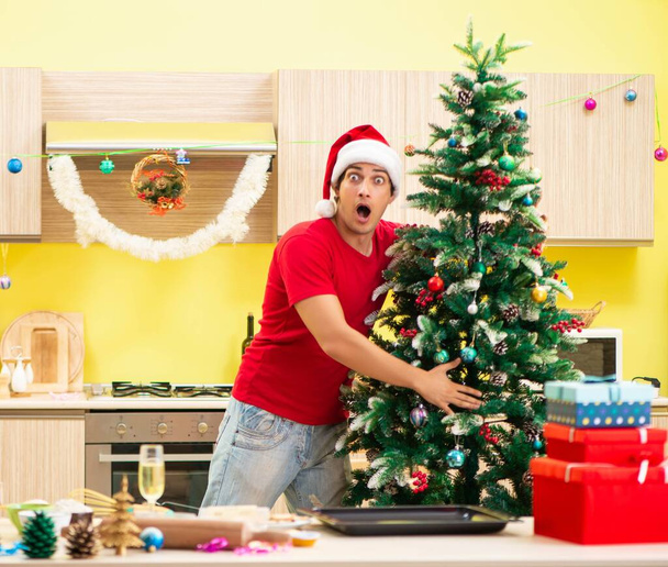 Jeune homme célébrant Noël dans la cuisine - Photo, image